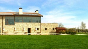A stone house with a large window and a small attached structure. - Hotel con encanto - SPA Kinédomus Bienestar (Fresnillo de las Dueñas)