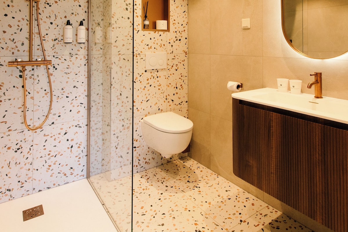 Une salle de bain moderne équipée d’une douche, de toilettes et d’un meuble-lavabo.