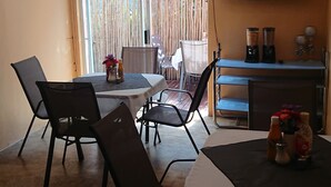 Un comedor con una mesa, sillas y un televisor instalado en la pared.