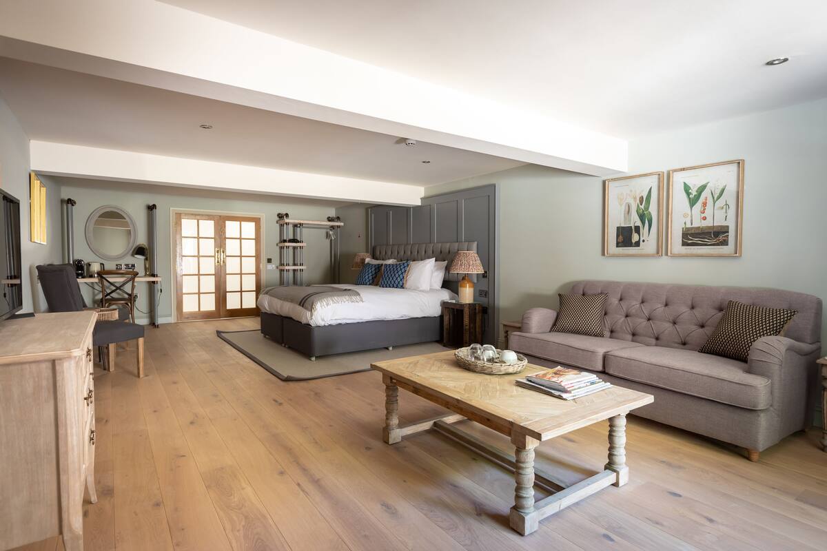 A spacious living room with a large bed, a sofa, and a coffee table.