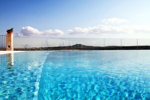 Una piscina al aire libre, sillones reclinables de piscina