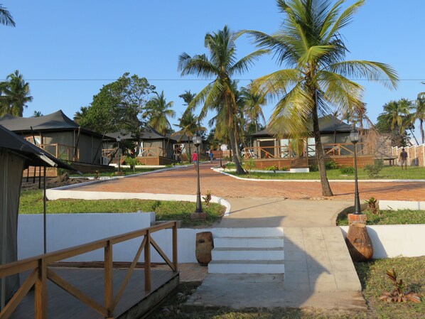 A resort with multiple bungalow-style accommodations, a central paved walkway, and palm trees. - Vertigo Lodge de Estuario (Inhambane)
