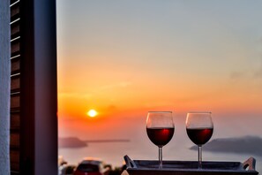 Two wine glasses on a tray with a sunset view. - Villa Renieris (Santorini)