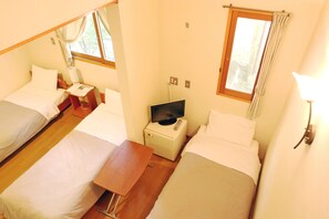 A room with two beds, a small table, a TV, and a window with curtains. - Forest Resort Cosmos (Fujikawaguchiko)