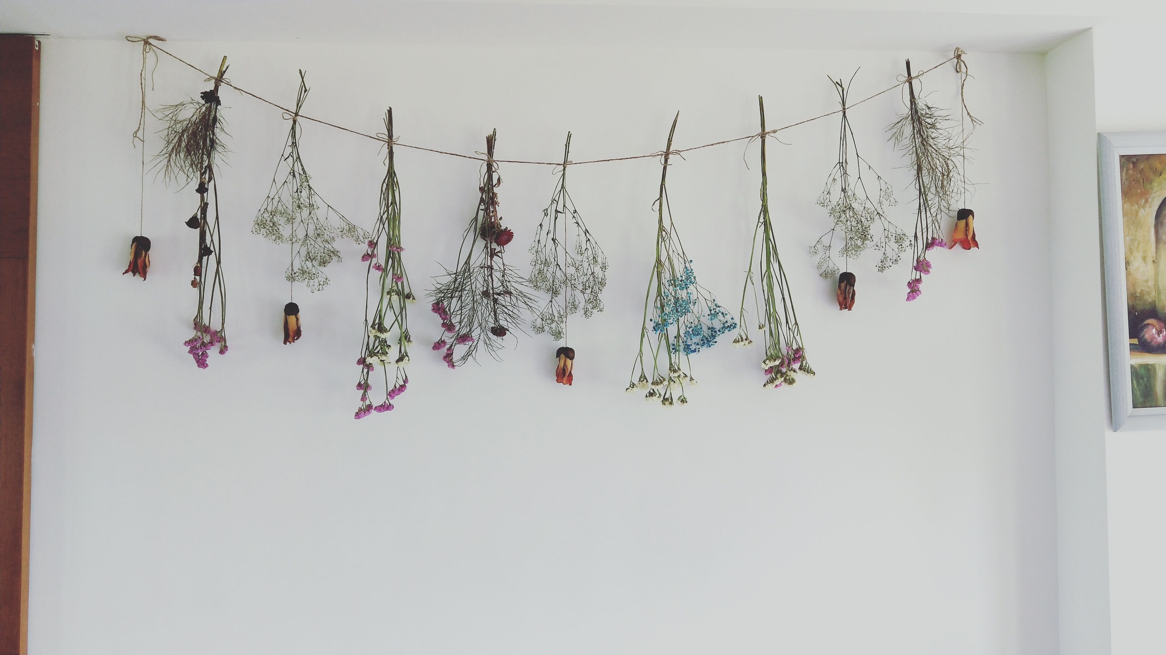 Una pared decorada con una guirnalda de flores y ramas secas.