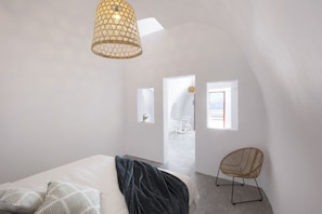 Une chambre à coucher moderne avec un lit, une chaise et un luminaire suspendu.