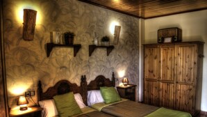 A bedroom with two beds, wooden headboards, and bedside tables with lamps.