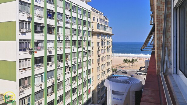 Een hotel met meerdere verdiepingen en balkons met uitzicht op een strand.