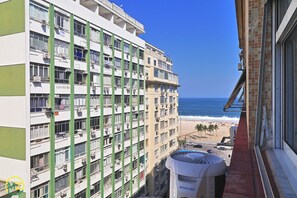Un hôtel à plusieurs étages doté de balcons donnant sur une plage.