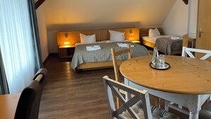 Un dormitorio acogedor con dos camas, una mesa de madera con sillas y una ventana con cortinas.