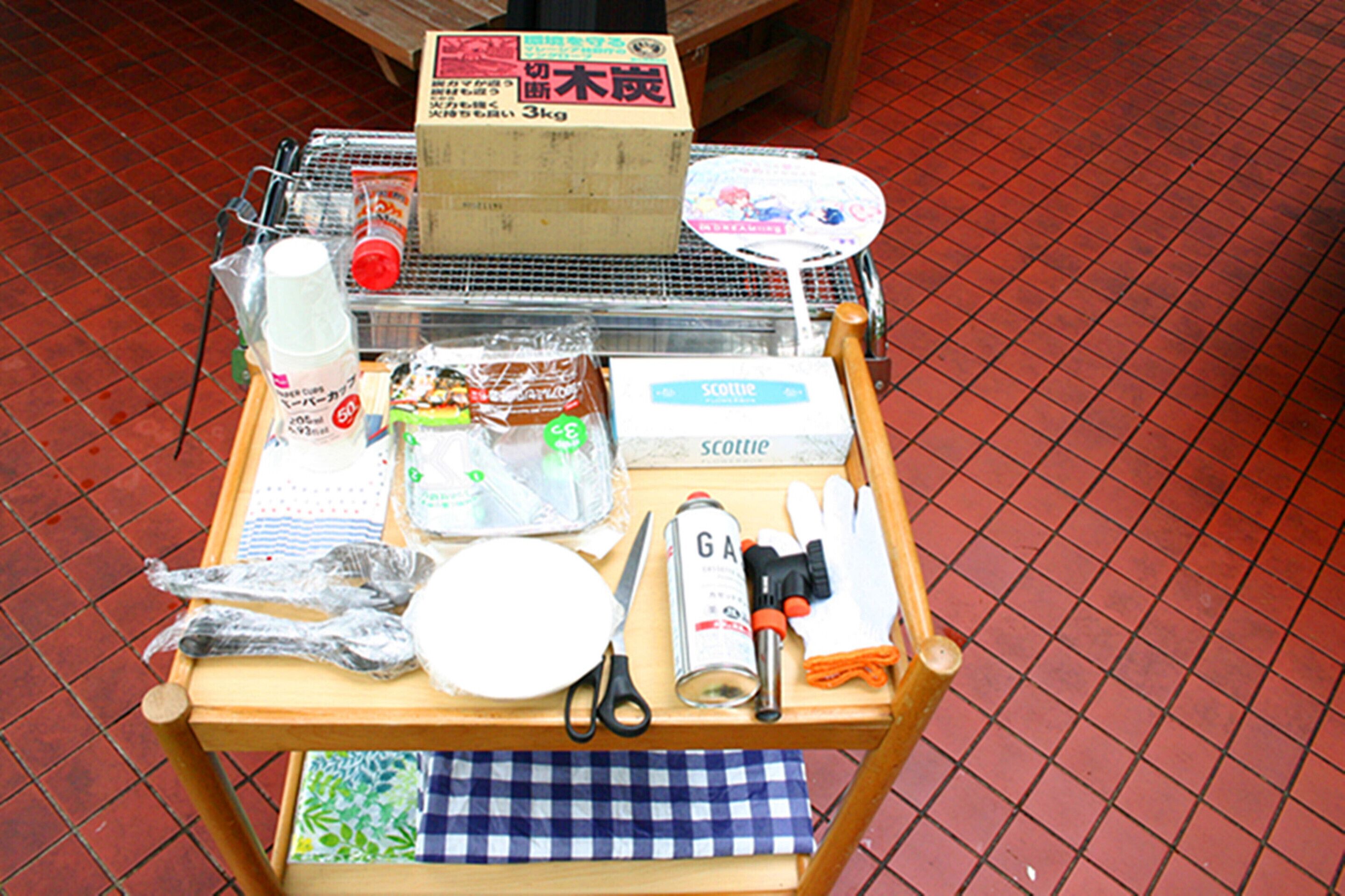 A table with a variety of items including a box labeled '3kg', a can of 'GA', scissors, a bottle, and a plate.
