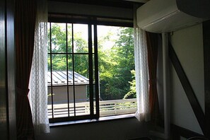 A room with a large window, curtains, and an air conditioning unit. - Pension Marie (Yamanakako)