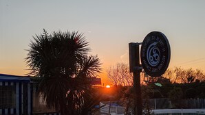 A sunset with a sign reading "Brasserie Alhambra - Henz - Menez are Briez."