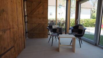 Una stanza con un muro in legno, due sedie e un tavolo.