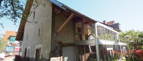 Un edificio moderno con grandes ventanales, fachada de piedra y techo inclinado.