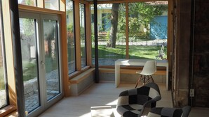 A spacious room with large windows, a wooden bench, and two chairs. - DIE KRONE - Hotel Garni (Kirchzarten)