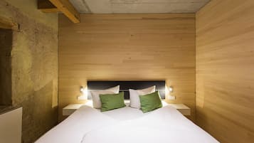 A room with a bed, wooden walls, and a headboard with lights.