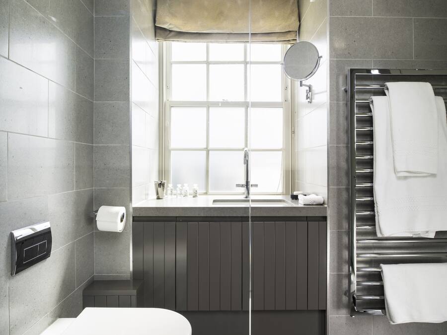 Ein modernes Badezimmer mit Toilette, Waschbecken und Handtuchhalter.