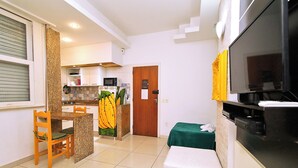Una cocina compacta con comedor, microondas y refrigerador.