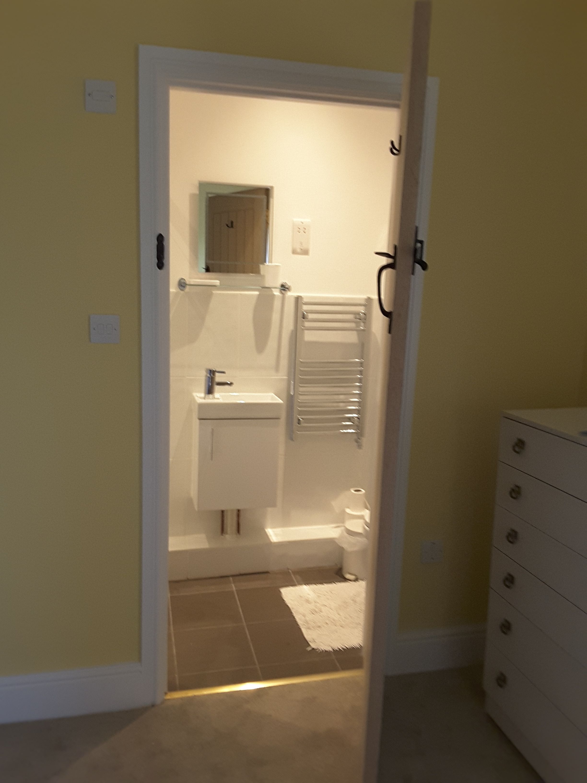 A bathroom with a toilet, sink, and towel rack.
