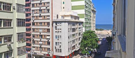 A multi-story building with a street view, including a pedestrian crossing and parked cars.