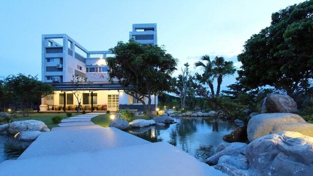 A modern hotel with a pool, large rocks, and a pathway leading to the entrance. - The Green Mile Field B&B (Ji'an)