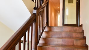 A staircase with wooden railings and brown tiled steps leading to a glass door. - Bojur & Bojurland Apartment Complex (Bansko)