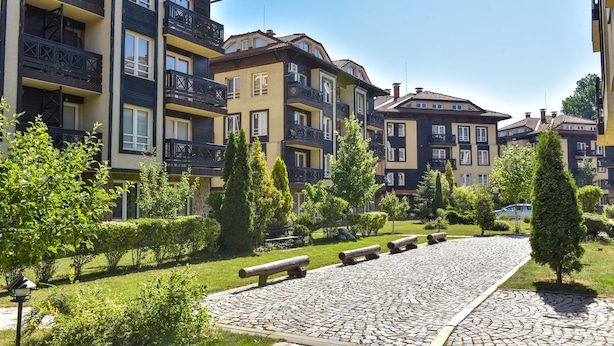 A residential building with multiple balconies, a cobblestone pathway, and well-maintained greenery. - Bojur & Bojurland Apartment Complex (Bansko)