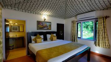A bedroom with a bed, a bedside table, a mirror, a painting, an air conditioner, and a window with curtains.