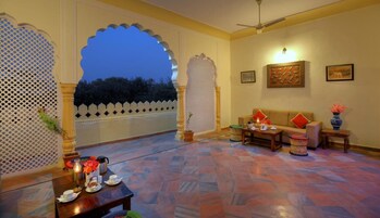 Amplia habitación con un gran arco de entrada a un espacio exterior, un sofá, una mesa de centro y un adorno en la pared.