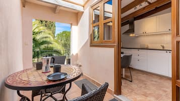 Enjoy meals in the kitchen with a stove and dining area with a round table and wicker chairs.