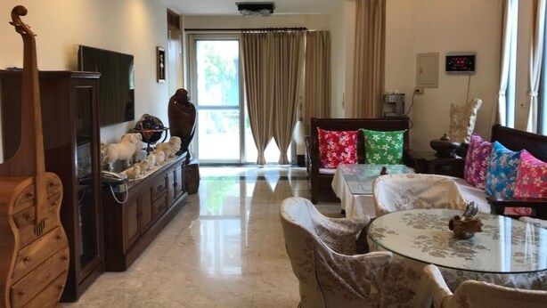 A spacious living area with a glass coffee table, comfortable seating, a wooden cabinet, and a television. - Guoguang B&B (Hualien City)