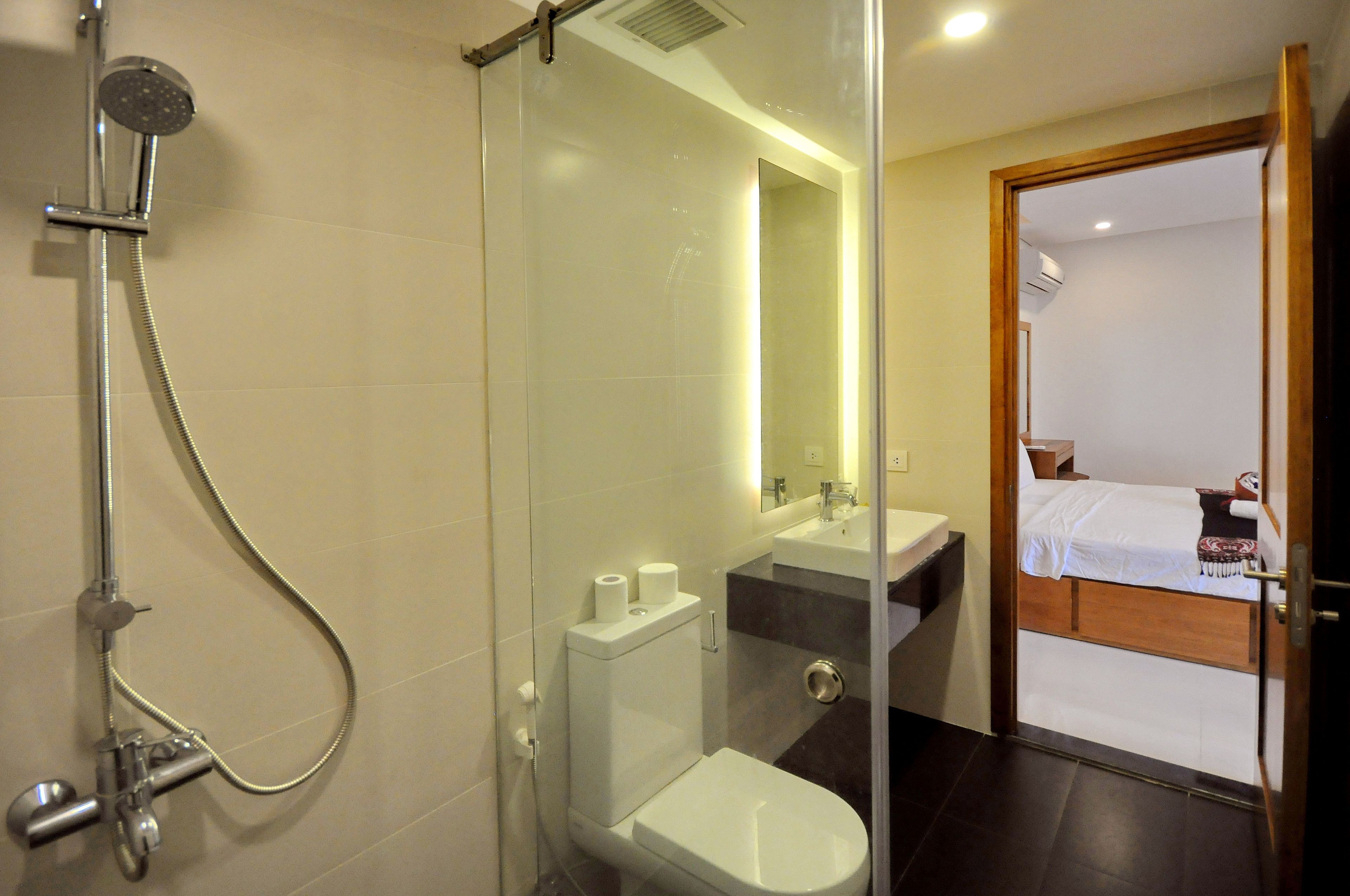 A modern bathroom with a glass shower enclosure, a toilet, and a sink.