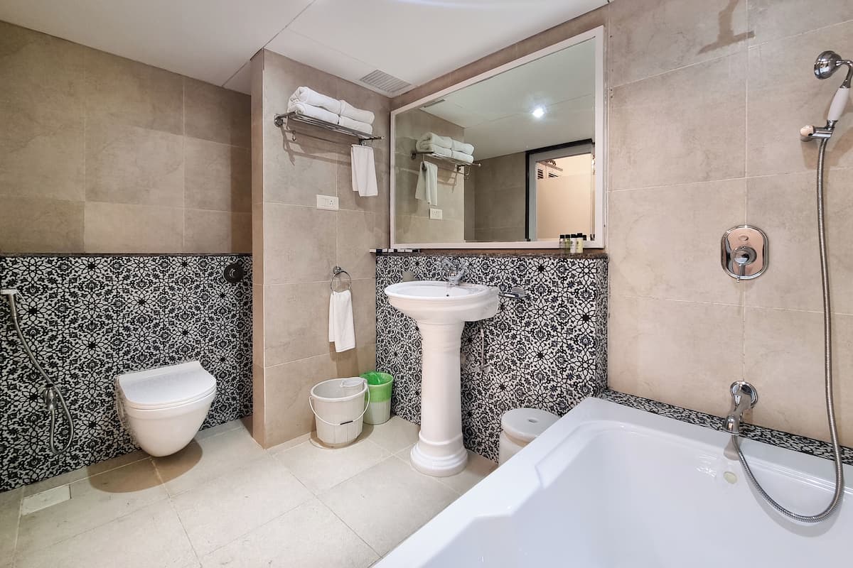 Ein modernes Badezimmer mit Toilette, Bidet, Waschbecken und Badewanne.