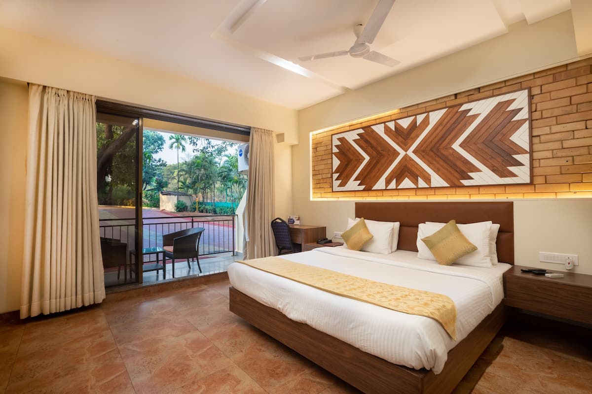 Ein Hotelzimmer mit einem großen Bett, einem Deckenventilator, Blick ins Freie und einer Wanddekoration aus Ziegeln.