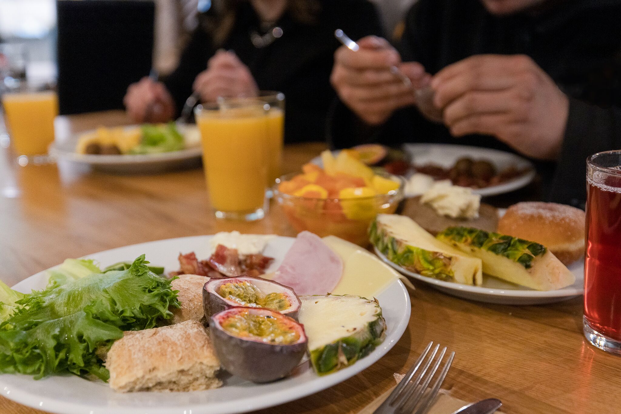Une table à manger avec divers plats, notamment des salades, de la viande et des fruits.