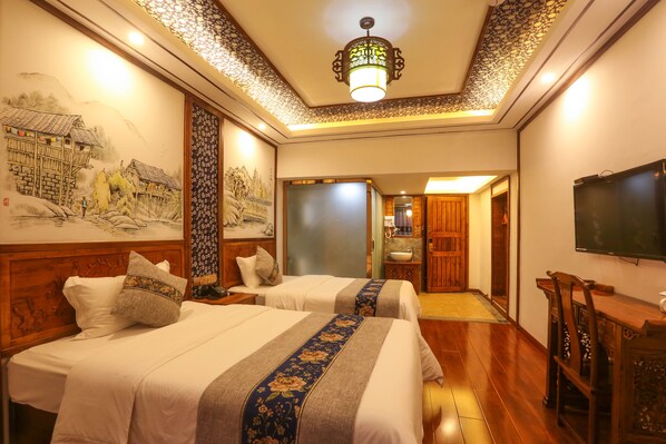 A hotel room with two beds, a television, and a bathroom visible through an open door. - Tusi-courtyard (Zhangjiajie)