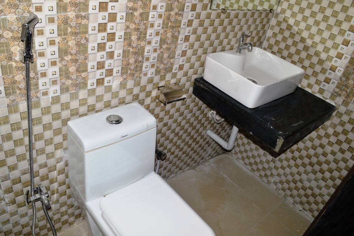 Une salle de bain avec des toilettes, un lavabo et une douche.