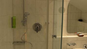 A modern bathroom with a glass-enclosed shower, a sink, and a mirror.