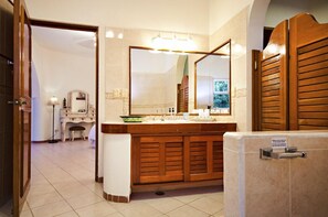A bathroom with a wooden vanity, a large mirror, and a sink.