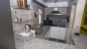 Appartement Deluxe ( Maracudja), 1 très grand lit et 1 canapé-lit, terrasse, côté jardin | Cocina compartida | Frigorífico, microondas, horno y placa de cocina