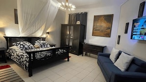 A bedroom with a bed, a sofa, a TV, and a cabinet. - Redoute Paradise (Fort-de-France)
