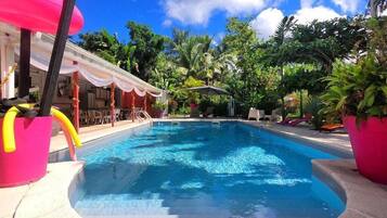 Una piscina al aire libre, sombrillas, tumbonas