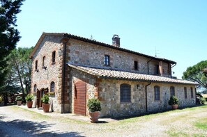 A stone building with a tiled roof, multiple windows, and a large wooden door. - Agriturismo Sant'Angelo (Acquapendente)