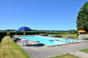 A swimming pool with lounge chairs and umbrellas, surrounded by a well-maintained lawn and hedges. - Agriturismo Sant'Angelo (Acquapendente)