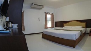 A hotel room with a bed, a desk with a computer, an air conditioner, and a window with curtains. - Maerim Whale Park Resort (Mae Rim)