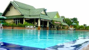 A swimming pool with lounge chairs and a building with a green roof in the background. - Maerim Whale Park Resort (Mae Rim)
