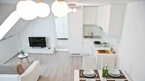 A modern apartment with a dining area, kitchen, and living space. - Apartments Hiša Pod Gradom (Ljubljana)