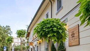 A cafe with outdoor seating, a wooden bench, and potted plants. - Apartments Hiša Pod Gradom (Ljubljana)