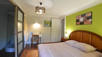 Cozy retreat with a large bed, desk, and chair, perfect for work or relaxation.